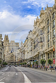 Beautiful buildings on the famous Gran Via shopping street and people walking in the center of the city in Madrid, Spain