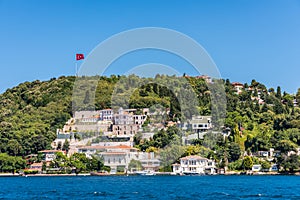 Beautiful builings and mansions at the costline and hillslope with Turkish national flag and green forest in summer, at Bosphorus