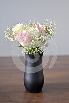 A Beautiful bunch of colored flowers with white buds in black vase