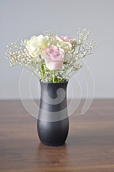 A Beautiful bunch of colored flowers with white buds in black vase