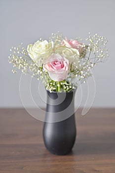 A Beautiful bunch of colored flowers with white buds in black vase