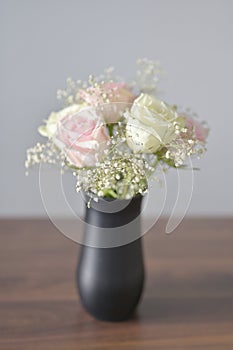 A Beautiful bunch of colored flowers with white buds in black vase