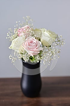 A Beautiful bunch of colored flowers with white buds in black vase