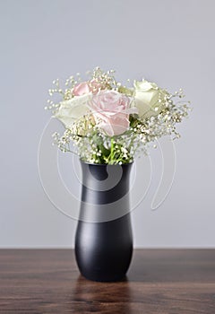 A Beautiful bunch of colored flowers with white buds in black vase