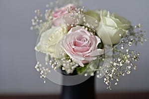 A Beautiful bunch of colored flowers with white buds in black vase