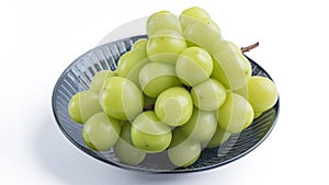 Beautiful a bunch of Shine Muscat green grape on a blue plate isolated on white background