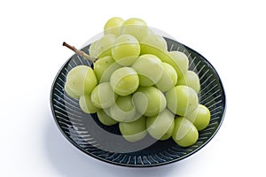 Beautiful a bunch of Shine Muscat green grape on a blue plate isolated on white background