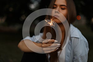 Beautiful burning Bengali fire with sparks in female hands