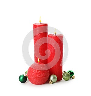 Beautiful burning candles with Christmas decor on white background
