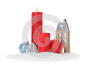 Beautiful burning candles with Christmas decor on white background