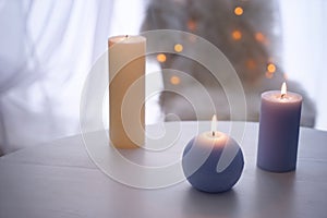 Beautiful burning candles on wooden table indoors