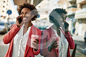 Beautiful business african american woman with afro hair smiling happy and confident outdoors at the city having a conversation