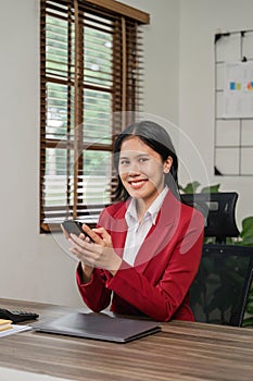 Beautiful business asian woman with working office desk using phone and computer laptop