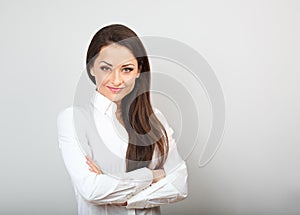 Beautiful business calm confident woman in white shirt looking with folded arms on background with empty copy space