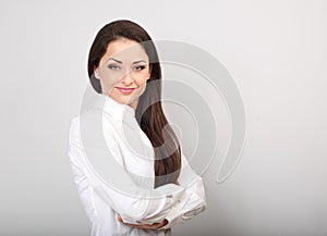 Beautiful business calm confident woman in white shirt looking with folded arms on blue background