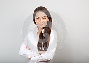 Beautiful business calm confident woman in white shirt looking with folded arms on blue color background