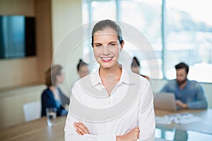 Beautiful business executive standing with her arms crossed in office