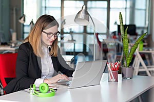 Beautiful Business Lady in official clothing working on Laptop