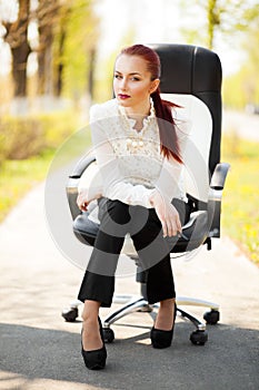 Beautiful business lady sitting on the office chair