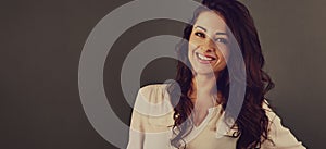 Beautiful business toothy enjoying laughing woman with long brown healthy curly hair style in white shirt clothing. Closeup