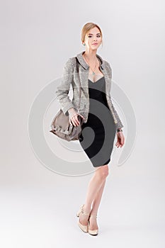 beautiful business woman blonde in black dress, jacket and purs