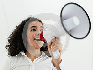 Beautiful business woman with curly hair holding a megaphone