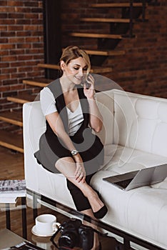 Beautiful business woman decides issues by talking on the phone. Soft selective focus, defocus