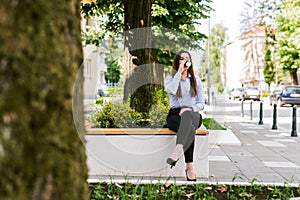 Beautiful business woman drinks coffee to go