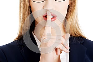 Beautiful business woman with finger on lips.