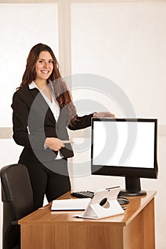 Beautiful business woman in her office with blank space on her monitor for additional text or graphic