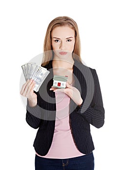 Beautiful business woman holding hpuse and dollars money.