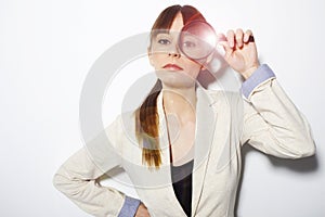 Beautiful business woman holding magnifying glass