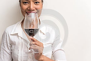 Beautiful business woman holding red wine glass for celebrate