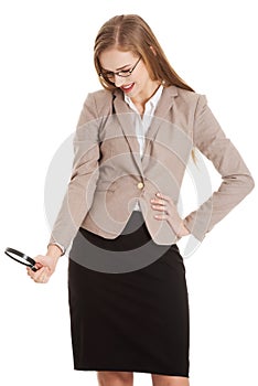 Beautiful business woman looking through magnifying glass.
