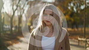 Beautiful Business Woman Looks and Smiles at Camera Standing in Autumn City Park