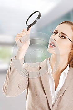 Beautiful business woman with magnifying glass.