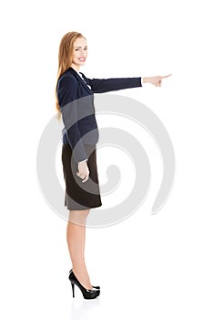 Beautiful business woman pointing on copy space.