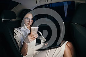 Beautiful business woman sitting in back seat of car