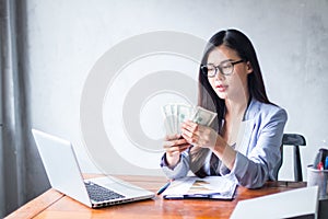 Beautiful business woman sitting at home office desk  using a laptop and smiling while working