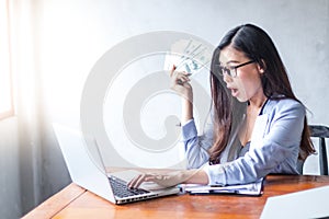 Beautiful business woman sitting at home office desk  using a laptop and smiling while working
