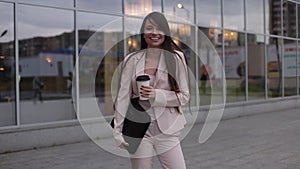Beautiful business woman smiling and holds the bag in her hand with coffee