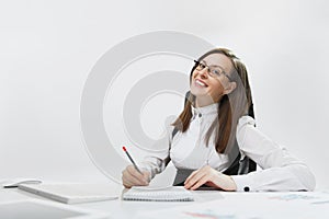 Beautiful business woman in suit and glasses working at computer with documents in light office