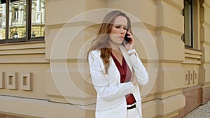 Beautiful business woman talking mobile phone outdoors