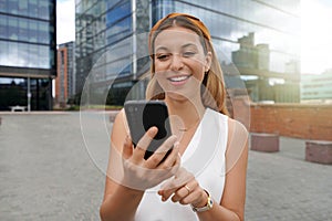 Beautiful business woman using mobile phone outdoors. People communication technology concept