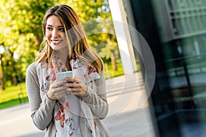 Beautiful business woman using mobile phone outdoors. People communication technology concept.