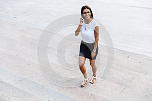 Beautiful business woman walking outdoors talking by mobile phone