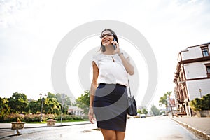 Beautiful business woman walking outdoors talking by mobile phone