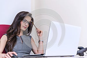Beautiful business woman working on computer at her office photo