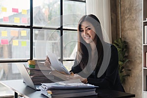 Beautiful Business woman working at home office and analyze financial report document. Accounting and Finance concept