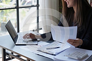 Beautiful Business woman working at home office and analyze financial report document. Accounting and Finance concept